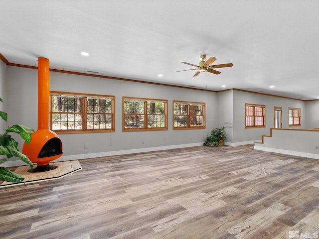 unfurnished living room featuring recessed lighting, ornamental molding, baseboards, and wood finished floors
