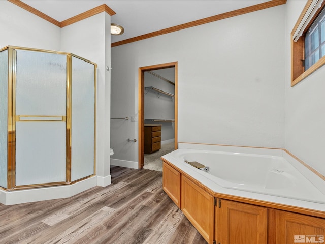 full bathroom with ornamental molding, wood finished floors, a bath, a spacious closet, and a stall shower