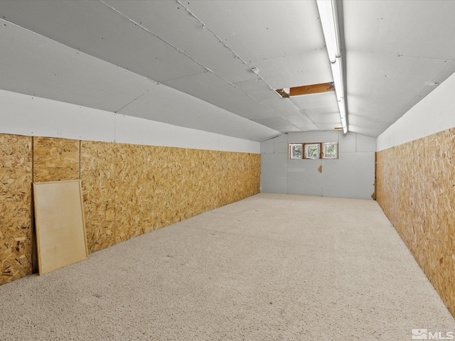 additional living space featuring wood walls, carpet, and vaulted ceiling