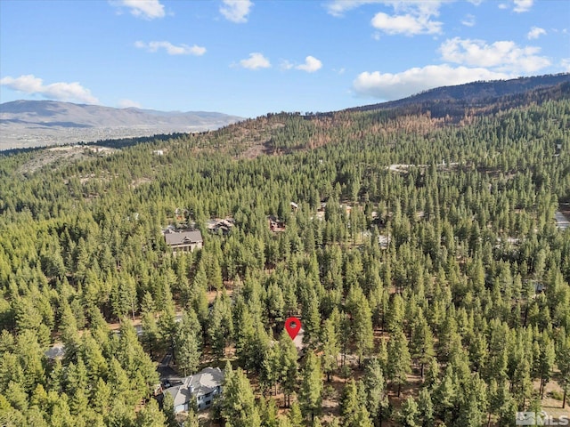 drone / aerial view with a wooded view and a mountain view