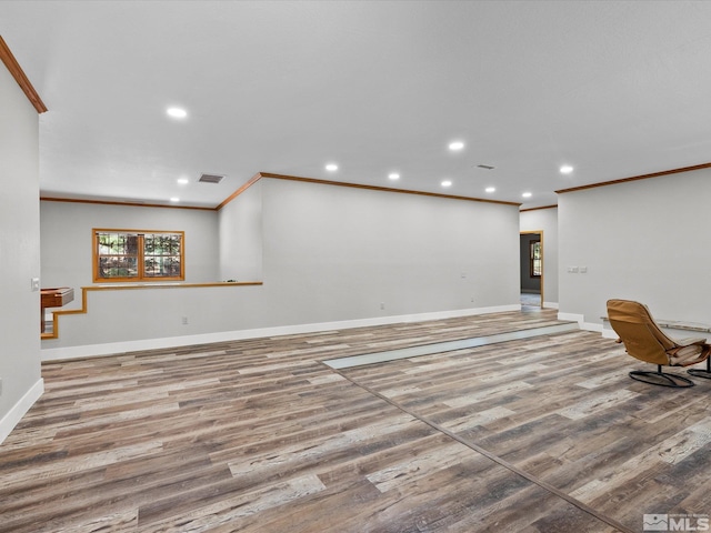 unfurnished living room with visible vents, crown molding, wood finished floors, baseboards, and recessed lighting
