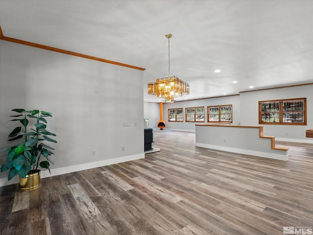 unfurnished living room with baseboards, ornamental molding, recessed lighting, and wood finished floors
