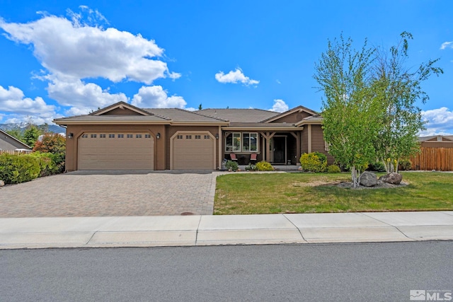 ranch-style home featuring fence, driveway, a front lawn, and a garage