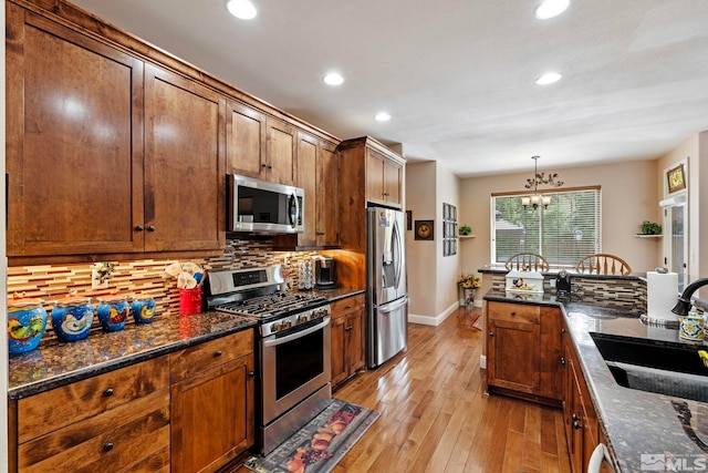 kitchen featuring a notable chandelier, a sink, stainless steel appliances, recessed lighting, and backsplash