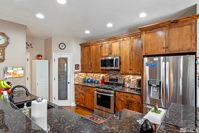 kitchen with brown cabinets, recessed lighting, appliances with stainless steel finishes, and tasteful backsplash