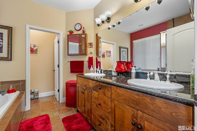 bathroom with double vanity, tiled bath, a sink, and tile patterned flooring