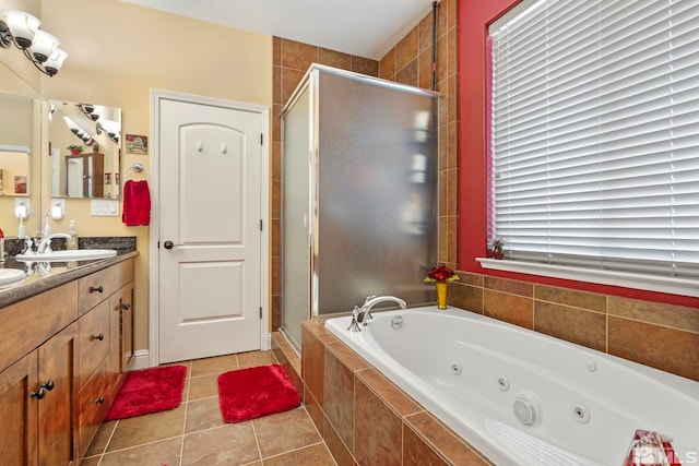 bathroom with double vanity, tile patterned flooring, a stall shower, and a tub with jets