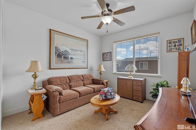 carpeted living room featuring a ceiling fan and baseboards