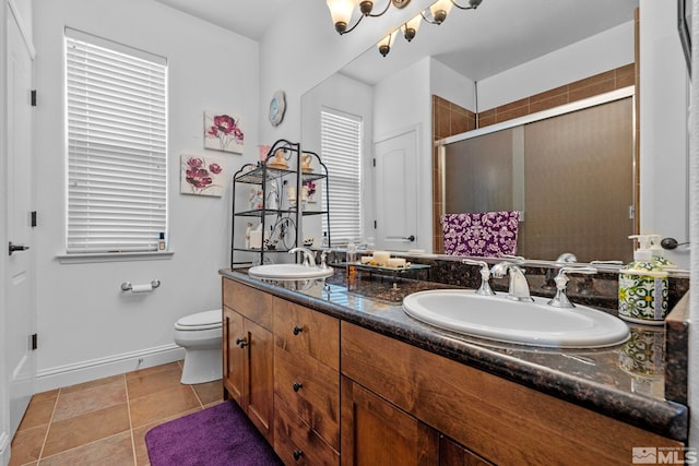 full bath with a sink, a shower stall, toilet, and double vanity