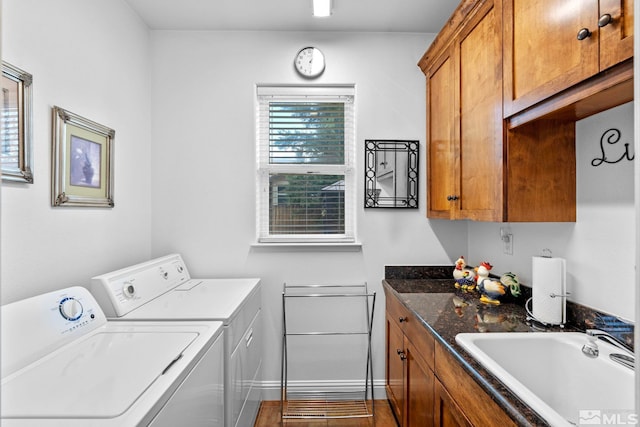laundry area featuring a sink, separate washer and dryer, baseboards, and cabinet space