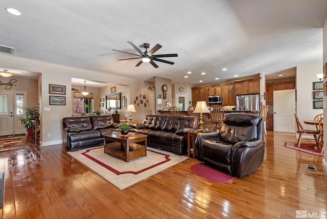living area with visible vents, baseboards, ceiling fan, recessed lighting, and light wood finished floors