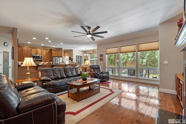 living room with baseboards, light wood-type flooring, a ceiling fan, and recessed lighting
