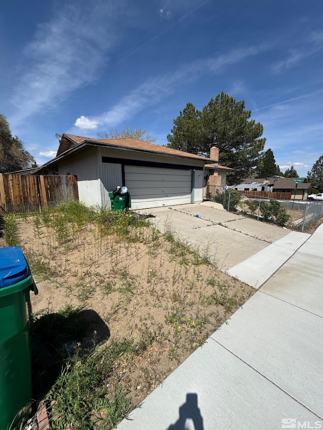view of front of home featuring fence and a garage