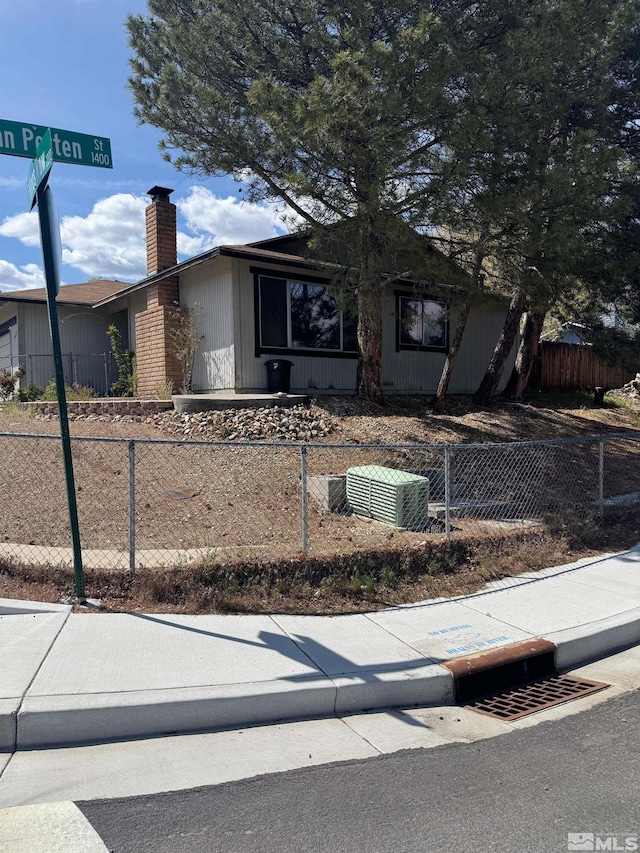 ranch-style home with a fenced front yard and a chimney