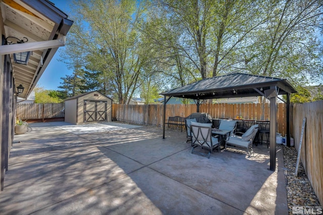 view of patio / terrace with outdoor dining space, a gazebo, a storage shed, a fenced backyard, and an outdoor structure