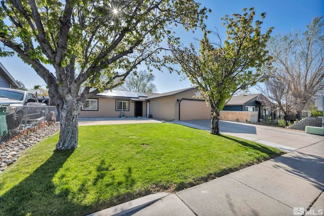 ranch-style home with driveway, solar panels, fence, an attached garage, and stucco siding