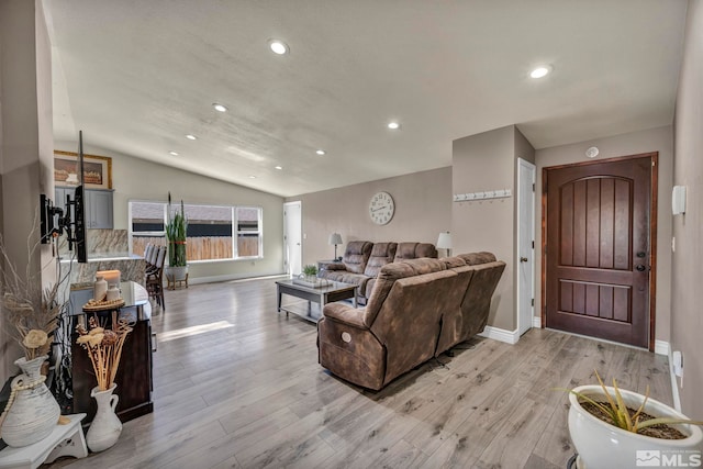 living room featuring baseboards, recessed lighting, light wood-style floors, and vaulted ceiling