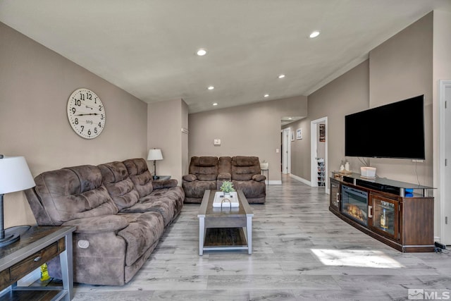 living room with recessed lighting, baseboards, and wood finished floors