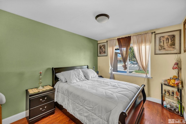 bedroom featuring baseboards and wood finished floors