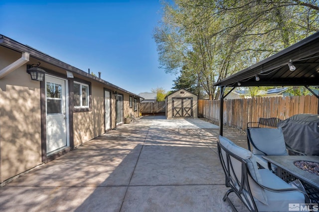 view of patio / terrace featuring a storage unit, a fenced backyard, and an outdoor structure