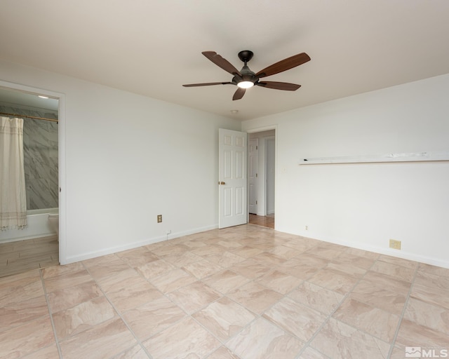 unfurnished bedroom featuring baseboards, a ceiling fan, and ensuite bath
