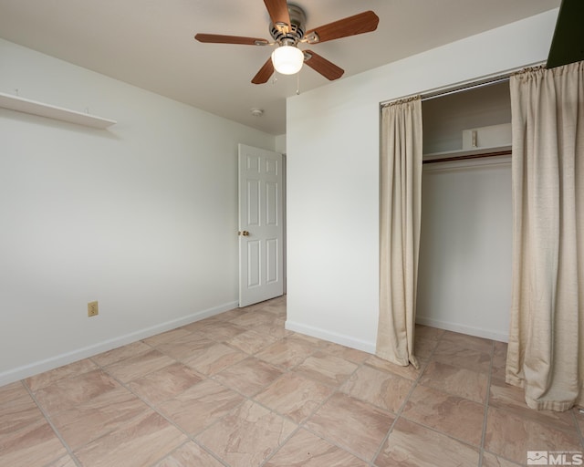 unfurnished bedroom featuring a ceiling fan, baseboards, stone finish floor, and a closet