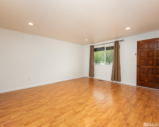 spare room with recessed lighting, baseboards, and light wood-style floors