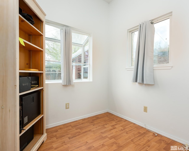 unfurnished room with baseboards and wood finished floors