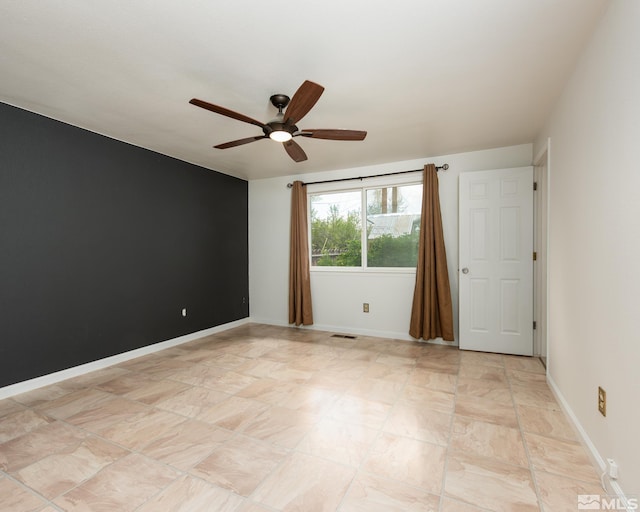 spare room with a ceiling fan, baseboards, and visible vents