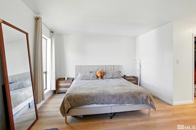 bedroom with light wood-style floors and baseboards