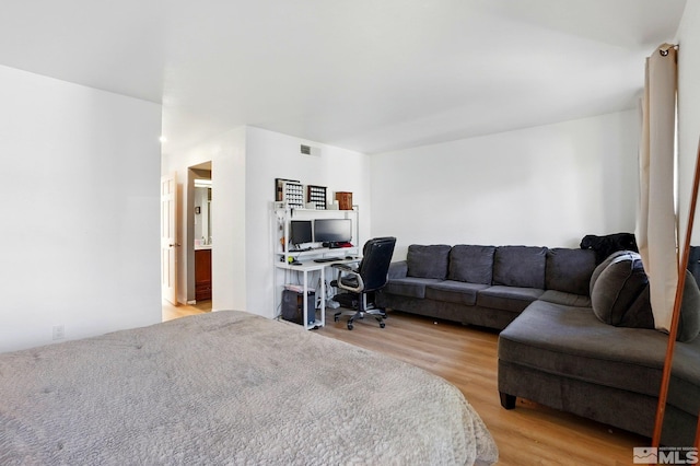 bedroom with light wood finished floors and visible vents