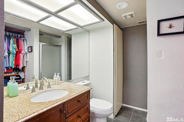 bathroom featuring visible vents, tile patterned flooring, a shower stall, vanity, and toilet