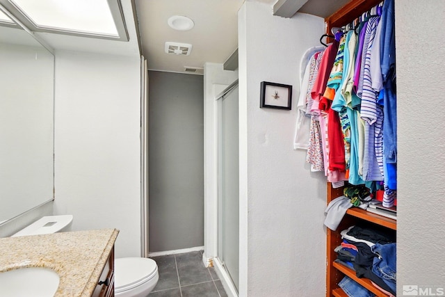 bathroom featuring visible vents, a stall shower, vanity, tile patterned floors, and toilet