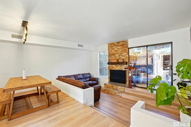 living area with visible vents, wood finished floors, and a fireplace