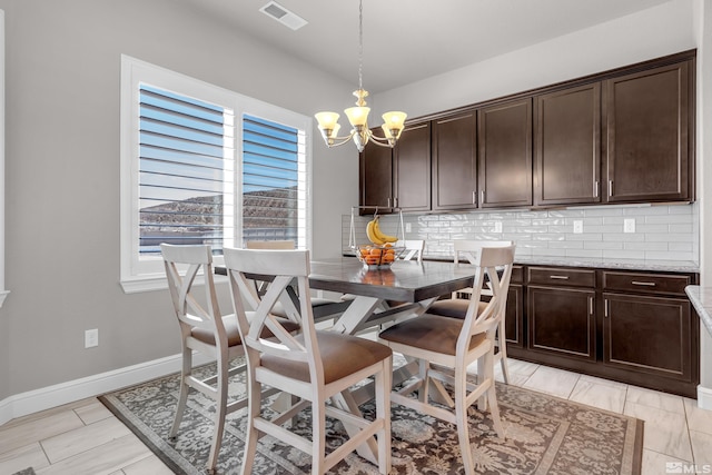 dining area with an inviting chandelier, baseboards, and visible vents