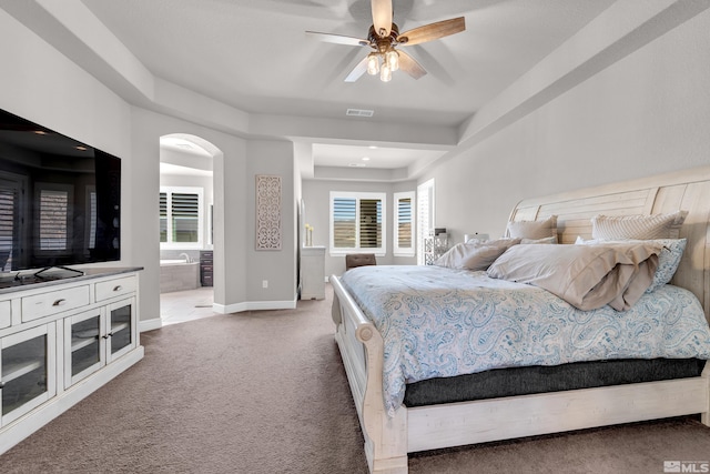 bedroom featuring light carpet, ensuite bath, a ceiling fan, baseboards, and visible vents