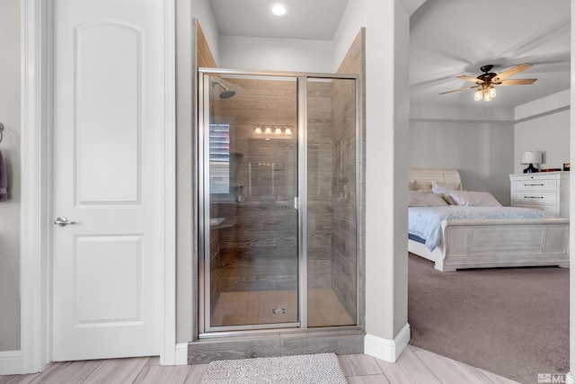 full bathroom featuring connected bathroom, ceiling fan, a shower stall, and baseboards