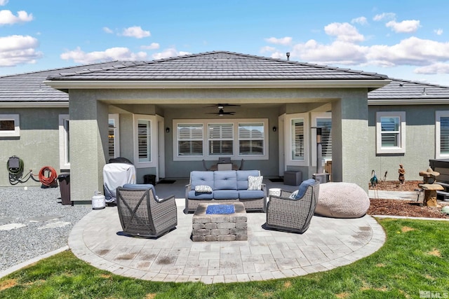 back of property featuring a ceiling fan, a tile roof, a patio, outdoor lounge area, and stucco siding