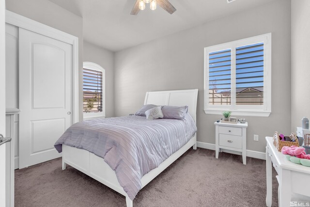 carpeted bedroom featuring baseboards and a ceiling fan