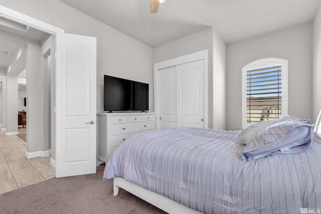 bedroom with light colored carpet, a ceiling fan, baseboards, visible vents, and a closet