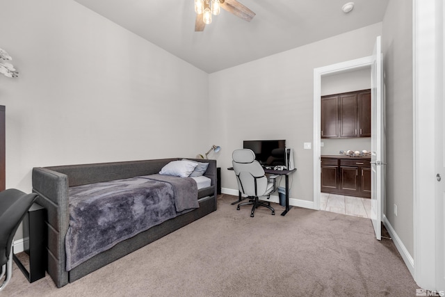 bedroom featuring ensuite bathroom, baseboards, ceiling fan, and light carpet