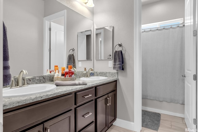 full bath with a sink, a shower with curtain, and double vanity