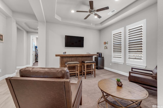 living area with ceiling fan, visible vents, a raised ceiling, baseboards, and recessed lighting
