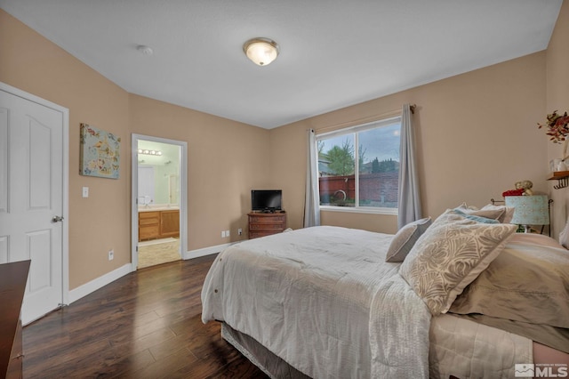 bedroom with baseboards, connected bathroom, and dark wood-style flooring