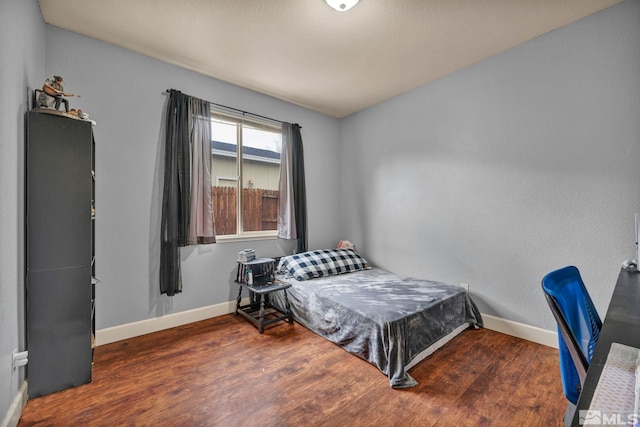 bedroom with baseboards and wood finished floors
