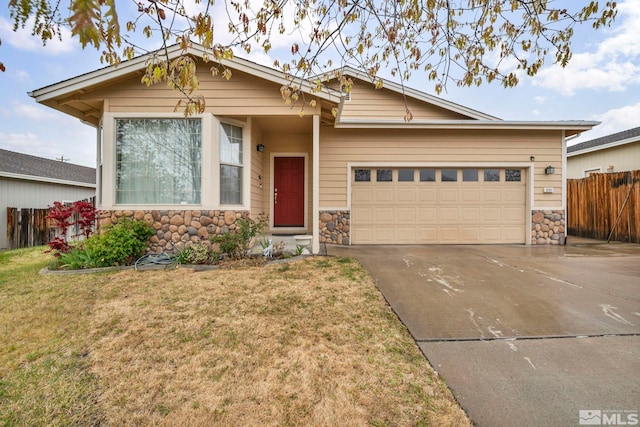 craftsman house featuring concrete driveway, an attached garage, fence, and stone siding