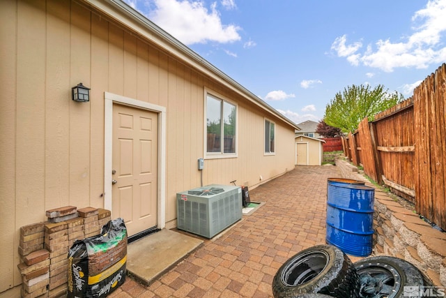 exterior space with a shed, a fenced backyard, cooling unit, a patio area, and an outdoor structure