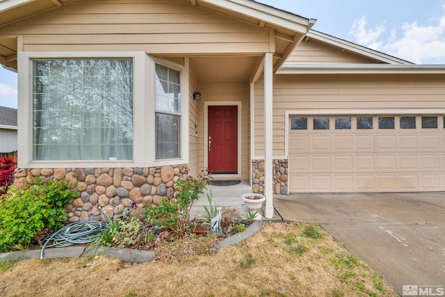 view of front facade with an attached garage, concrete driveway, and stone siding