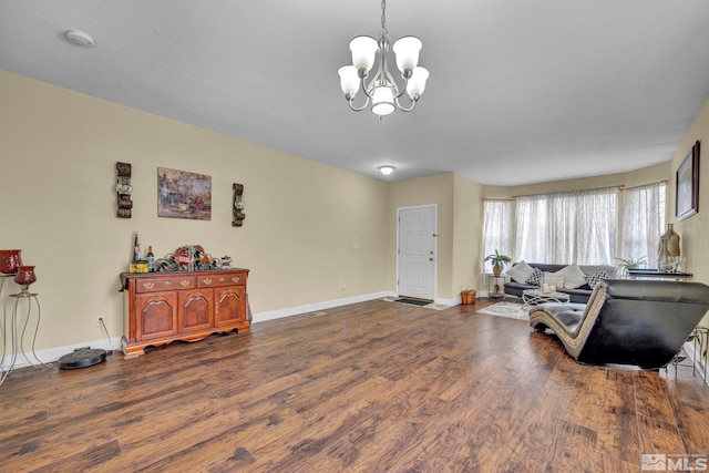 living room with an inviting chandelier, baseboards, and dark wood-style floors
