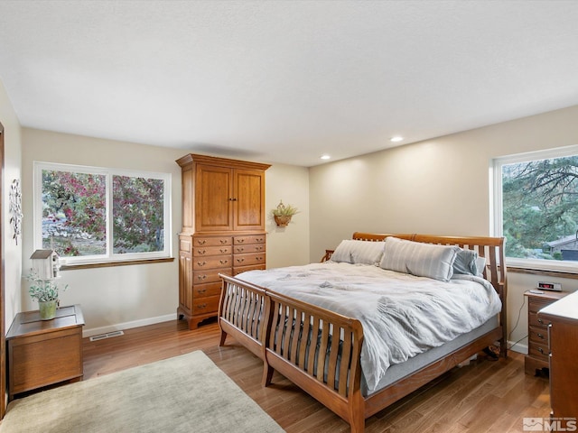 bedroom with light wood-style floors, recessed lighting, baseboards, and visible vents